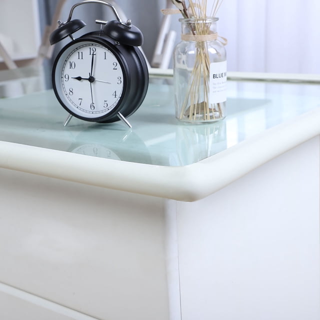 Unique Bargains 6.6ft Table Desk Edge Foam Edge Cushion Guard Strip Soft Bumper Protector in white, shown applied to the edge of a glass-topped table. The foam guard provides a soft, protective barrier to prevent injuries from sharp edges. Suitable for various surfaces like wood, glass, and metal, it is ideal for baby proofing and furniture protection.