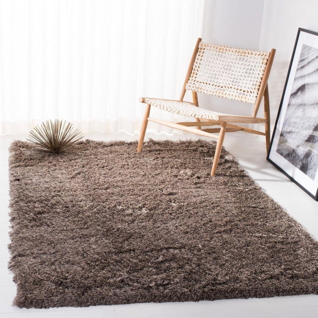Safavieh Paris Darwin Tapis Shag en Peluche Brun Doux avec Épais Poil Peluche et surface Riche en Texture, Conçu comme un Tapis d'Accent sur un Plancher Clair à Côté d'Une Chaise en Bois avec Siège et Dossier Tissés Blancs, et une photo Encadrée Noir et Blanc Adossée au Mur.