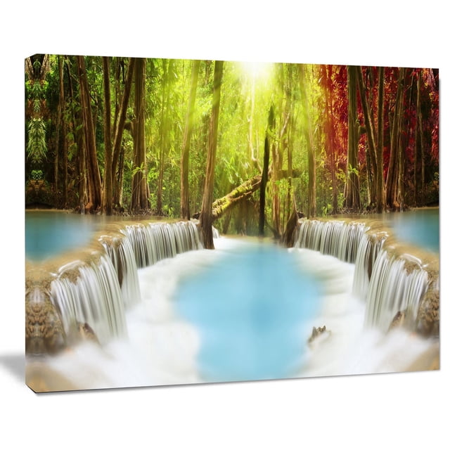 Design Art Huai Mae Kamin Waterfall Canvas Print showing a gallery wrapped cotton canvas with a turquoise waterfall flowing into a pool, surrounded by green and red forest trees, ready to hang wall art suitable for home or office décor.
