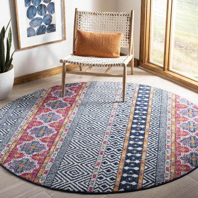 Safavieh Madison Kandace Abstract Area Rug round with multicolored geometric and floral patterns in navy blue, pink, yellow, and white, power loomed for durability, placed on a light wood floor under a woven chair with a burnt orange cushion near a large window, ideal for adding vibrant style to contemporary home decor.