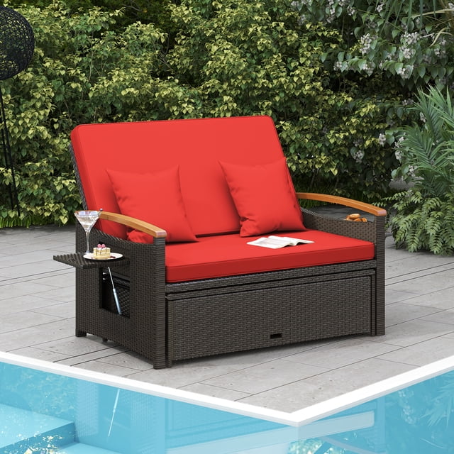 Costway Ensemble de Rotin pour Patio Daybed avec Causeuse Rembourrée et Pouf de Rangement Rouge, Exposé sur un Patio Près d'Une Piscine. le Causeuse Est Fabriqué avec Mélange de Rotin PE Brun, de Coussins Rouges et d'Accoudoirs en Bois d'Acacia. Il Comprend des Plateaux Latéraux Rétractables pour Tenir des Articles et un Pouf Polyvalent Qui Fait Aussi Office de table Basse avec Rangement Interne. le Cadre Est Entouré de Verdure.