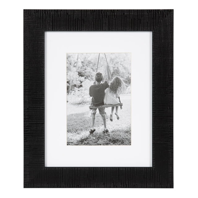 hometrends Tofino Black Picture Frame with a textured black two-tone finish, holding a 5x7 inch black and white photo of two children sitting on a swing outdoors, displayed with a white mat border, suitable for vertical or horizontal tabletop or wall display, often used to personalize home or office décor.