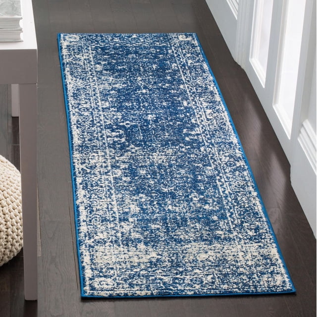 Safavieh Evoke Denica Tapis de Couloir Rectangulaire Traditionnel avec Motif Bleu et Blanc Usé, Fabriqué à Partir de Fils de Polypropylène Tissés Mécaniquement Durables, Exposé sur un Plancher de Bois Franc Foncé Près d'Une Porte Blanche et d'Un pouf Tricoté beige, Convient aux Espaces Domestiques Décontractés et Très Passants.