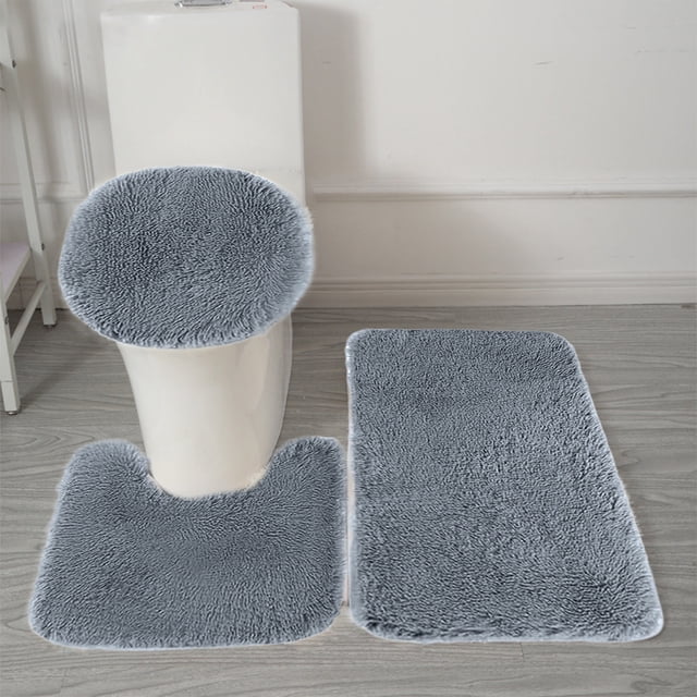 weibbin 3 Pcs Bathroom Rugs in a solid gray color, featuring a soft velvet fleece surface with memory foam backing. The set includes a rectangular bath mat, a U-shaped toilet mat, and a toilet lid cover, all designed for water absorption, non-slip functionality, and easy machine washing. Displayed in a modern bathroom setting with light wood flooring.