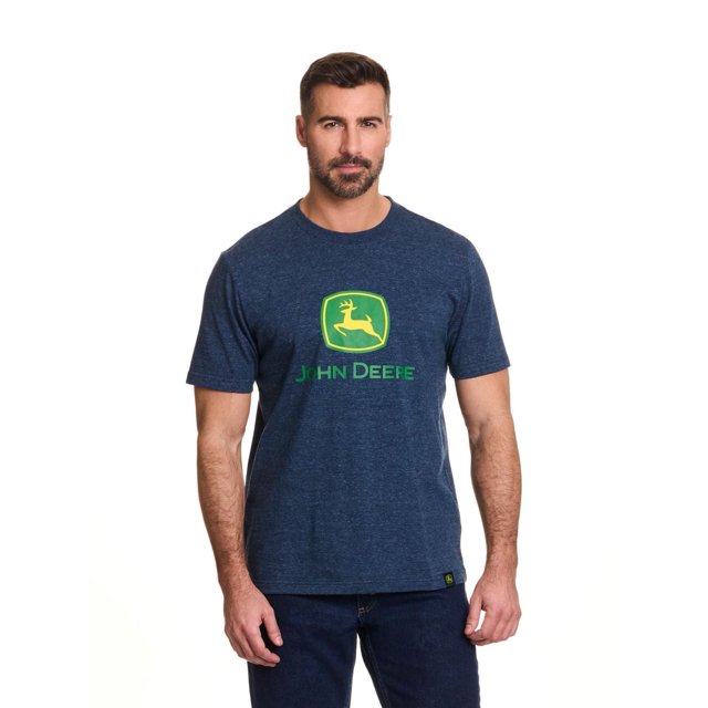 John Deere Men’s Logo Graphic Short Sleeve Tee in navy blue jersey fabric featuring the green and yellow John Deere core logo screen printed on the chest, shown front-facing on a male model wearing dark blue jeans, ideal for casual wear or pairing with John Deere shorts or pants.