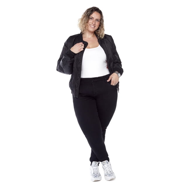 Frankie & Stella ™ Regular Rise Skinny PLUS - Black jeans shown on a plus-size woman standing front-facing. These black skinny jeans have a mid-rise waistband, zip fly closure, and embroidered back pockets. Made from stretch cotton butter denim, they offer a slim, shape-lifting fit. The model pairs them with a white tank top, black bomber jacket, and white sneakers, suitable for casual everyday wear.