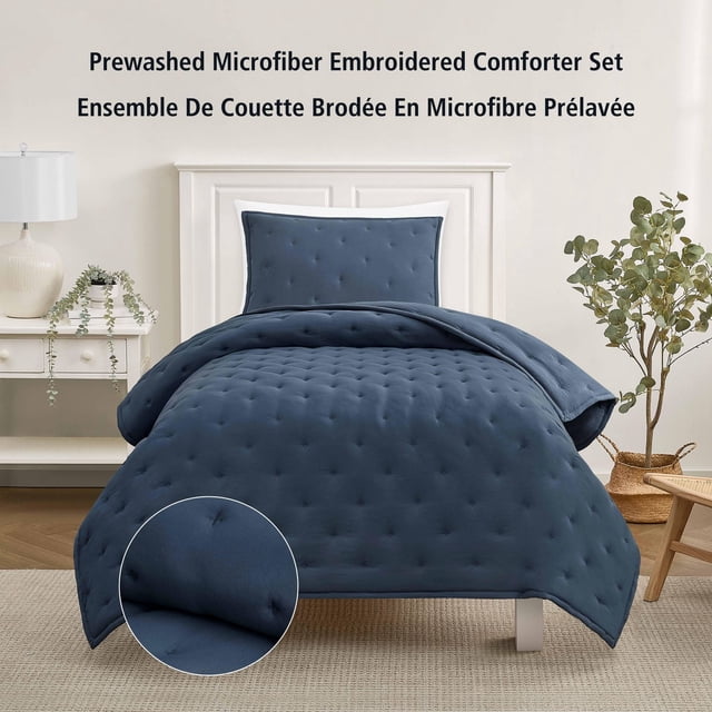 Ensemble de Couette Brodée en Microfibre Prélavée en indigo Lavé, Format Simple, avec Détails Tuftés sur une Couette Douce et Taie d'Oreiller Assortie sur un Cadre de Lit Blanc dans une Chambre Neutre. Cet Ensemble de Literie Lavable à la Machine Convient à Tous les Âges et Rafraîchit le décor de la Chambre.