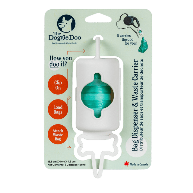 The Doggie Doo Dog Poop Bag Dispenser & Waste Carrier in a bone-shaped design, shown in white with a visible roll of green waste bags inside. The dispenser is packaged with clear instructions for clipping onto a leash, loading bags, and attaching waste bags. Made of durable material, it offers hands-free convenience for dog owners. The packaging highlights its Canadian origin and practical features for managing dog waste during walks.