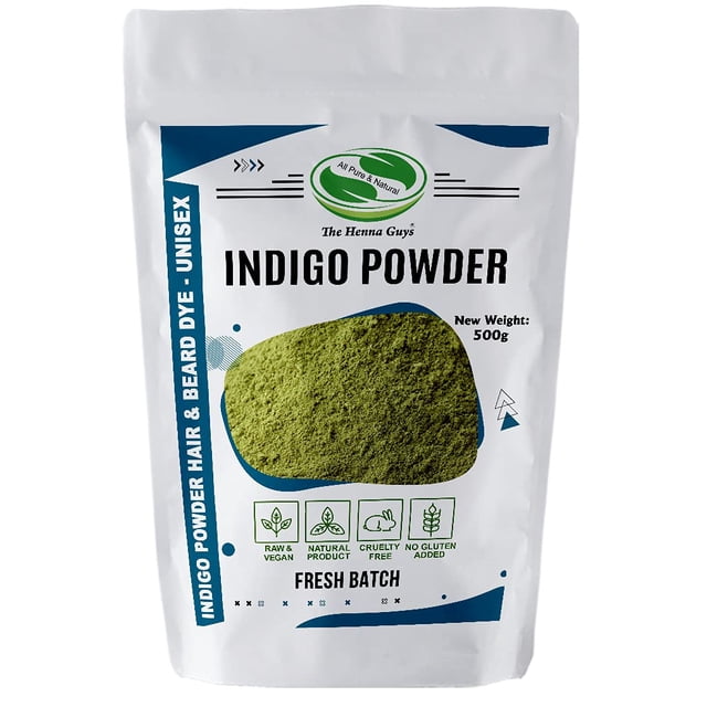 500 grams (1.2 lbs) of Indigo Powder for hair dye and color by The Henna Guys, packaged in a resealable white pouch with green and blue accents. The front of the pouch highlights features such as being raw, vegan, cruelty-free, and free of harmful additives, chemicals, and metallic salts. Suitable for natural hair coloring and conditioning, it can be mixed with pure henna to achieve dark brown or black hair color. The powder is triple sifted for a smooth, non-clumpy paste.