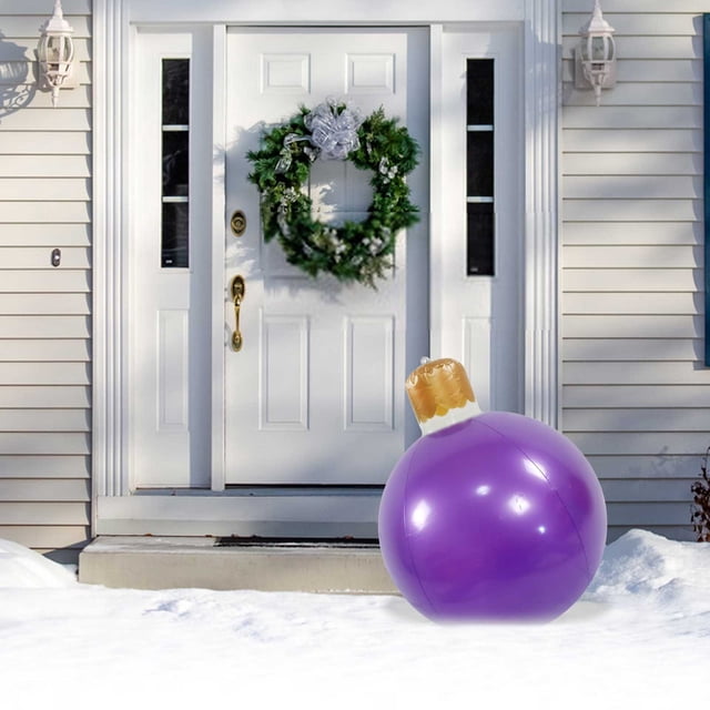 Vaidha 50cm Outdoor Christmas Inflatable Decorated Ball showcased in a snowy front yard. This giant inflatable ball features a bold purple design with a golden ornament-style top, perfect for enhancing outdoor holiday decorations. Positioned near a white front door with a green wreath, it adds festive charm and is ideal for Christmas inflatables displays.