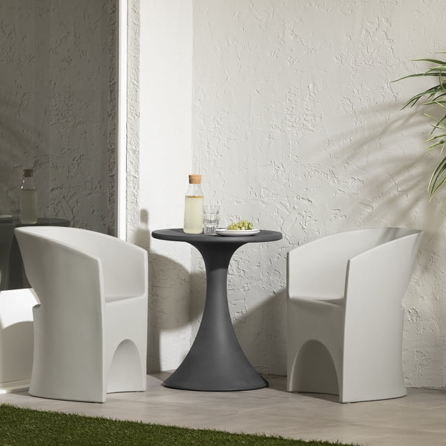 South Shore Dalya Table and Chairs Bistro Set in greige and dark gray, featuring a round dark gray polyethylene table with a flared pedestal base and two greige armchairs with rounded cutouts and armrests, set on a tiled floor against a textured white wall with a plant shadow and mirror reflection, styled with a glass bottle, two glasses, and a plate of green grapes, ideal for small patios or indoor spaces.