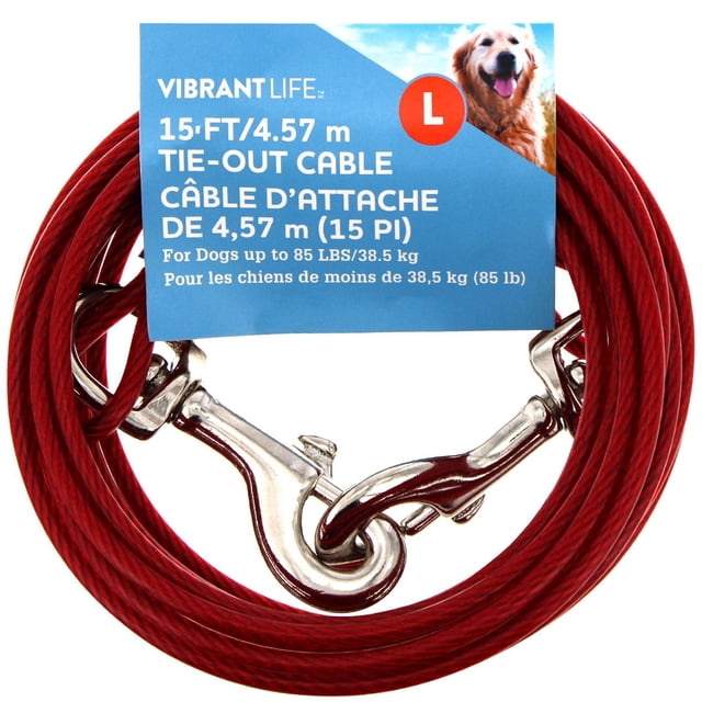 Vibrant Life 15 ft/4.57 m Dog Tie Out Cable coiled in red with two silver metal snap hooks, designed for dogs up to 85 lbs, featuring a blue label with product details and a golden retriever image, ideal for outdoor tethering and training.