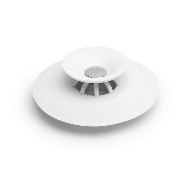 Umbra Flex Drain Stop - Hair Catcher in white, shown in a close-up 3/4 view on a white background, featuring a circular design with a raised center push-down stopper and slotted hair catcher, measuring 3 inches diameter by 1 inch height, fits standard tub and shower drains to prevent hair clogs and doubles as a tub stopper.