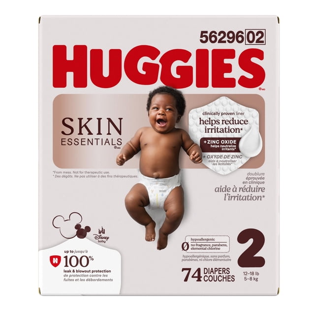Huggies Skin Essentials Baby Diapers Size 2 (12-18 lbs), 74 count box featuring a baby wearing a white diaper with Disney patterns, clinically proven zinc oxide liner to reduce irritation, hypoallergenic with no fragrance, parabens, or chlorine, and up to 100% leak and blowout protection.