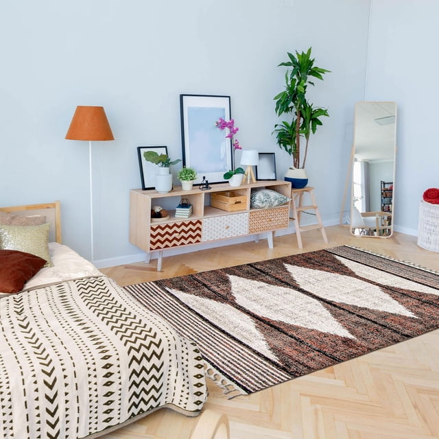 ECARPET Tapis du Sud-Ouest pour Couloir, Cuisine Losange Collection avec Motifs Géométriques en Losanges Bruns, Crème et Noirs sur un parquet en Bois Clair au Sol dans une Chambre Moderne avec un Couvre-Lit à Motifs, Buffet en Bois avec Plantes et Oeuvre Encadrée, Lampe sur Pied et Miroir Pleine Longueur. Idéal pour les Espaces Intérieurs Très Passants.