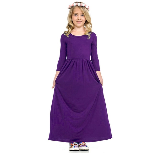 Robe Longue Décontractée à Fleurs pour Filles à Manches Longues avec Poches pour les Fêtes Robes pour Filles à Manches Longues Longueur au Sol Robe Maxi. la Robe Est Montrée dans une Couleur Unie Violette avec Manches Longues, une Taille Haute Élastique et un design Longueur au Sol. Fabriquée à 95 % polyester et 5 % Élasthanne, Elle Convient aux occasions de Printemps, d'Automne et d'Hiver comme les Fêtes, la Rentrée et le Port Quotidien. l'Image Met en Vedette une Jeune Fille Portant la Robe, avec un Bandeau Floral et des Chaussures Décontractées.