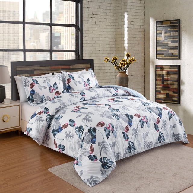 Marina Decoration Home Decor Ultra Soft Luxury Fluffy Goose Down Alternative Bedding Printed Comforter Set featuring a modern green leaves pattern with blue, red, grey, and brown accents on a white base, box-stitched and overfilled for durability and comfort, displayed on a bed with matching pillow shams in a bright bedroom with wooden flooring and textured brick walls, ideal for year-round use and suitable for guest rooms or vacation homes.