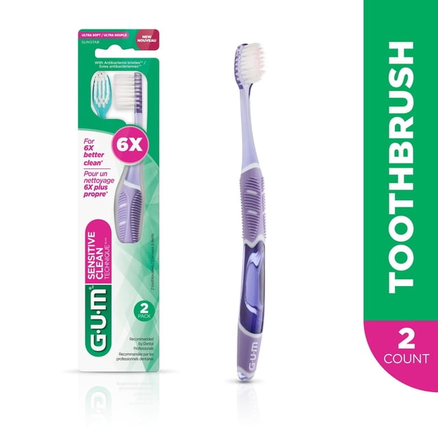GUM® TECHNIQUE® Brosse à Dents Sensitive Clean Compacte avec Poils Antibactériens Ultra Doux et Manche Violet-Blanc à Quatre Poignées® Conçue pour l'Élimination Douce de la plaque et un Brossage optimal à 45°, Montrée dans l'Emballage et Autonome sur Fond Blanc.