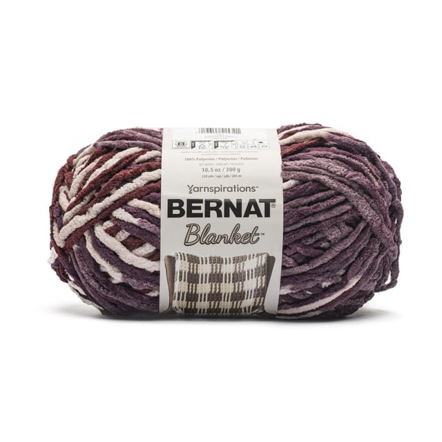 Bernat® Blanket™ #6 Super Bulky Polyester Yarn in Plum Preserves, 10.5oz/300g, 220 yards, shown as a skein of chenille-style bulky yarn in plum, burgundy, and cream with a white label featuring the Bernat logo and a knitted blanket image, suitable for quick home décor projects and machine washable.