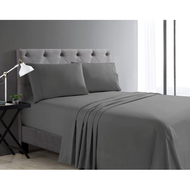 Swift Home Basic 4-Piece Queen Size Sheet Set in gray on a queen bed with a tufted gray upholstered headboard, including deep pocket fitted sheet, flat sheet, and two pillowcases. The ultra-soft, breathable fabric fits mattresses up to 16 inches deep, shown wrinkle-free and smooth. The bed is in a modern room with a dark gray wall, black side table with white lamp and small plant, and a window with sheer white curtains. This set is also ideal for guest rooms or dorms.