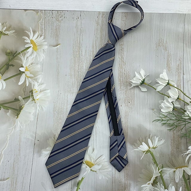 Baby Care Children's Tie Striped Patterned Accessory for Kids Suitable for Daily Casual Graduation and Holiday Events. The tie features a classic striped design in grey with navy and gold accents, made from polyester material. It is displayed on a light wooden surface surrounded by white daisies, emphasizing its elegant and versatile style. Designed for children aged 3 to 16, it measures 38 cm in length and offers an adjustable fit for comfort.