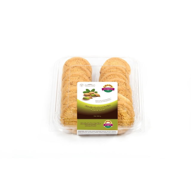 Pistachio Shortbread Cookies centered front view of stacked round shortbread biscuits with visible toasted pistachio pieces and golden edges; one broken biscuit shows interior crumbs; 350 g package labeled in background on a neutral kitchen surface. Often used for gifting or serving with tea.