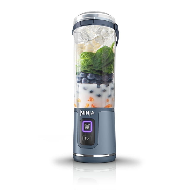 Ninja Blast™ Portable Blender Denim Blue, 18 oz, cordless personal blender with a blue base and digital start/stop button, filled with ice, spinach, blueberries, yogurt, and orange pieces, featuring a hinged carry handle and sip lid for on-the-go smoothies and protein shakes, also suitable for making frozen drinks.