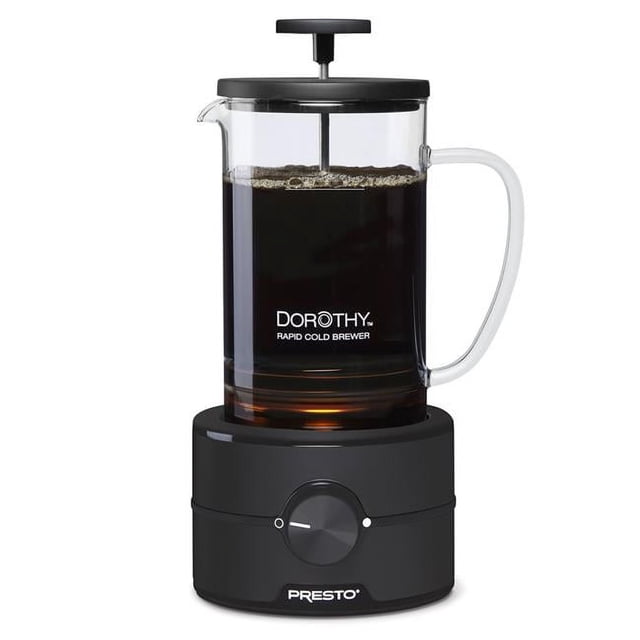 Presto 02937 22 oz Transparent Dorothy Rapid Cold Brew Coffee Maker featuring a transparent glass carafe with a black lid and plunger, set on a black detachable power base with a speed control dial. The carafe is filled with dark coffee, showcasing its 22 oz capacity. Designed for quick cold brew preparation in just 15 minutes using rapid spinning technology for smooth, flavourful coffee without bitterness. Dishwasher-safe components for easy cleaning.