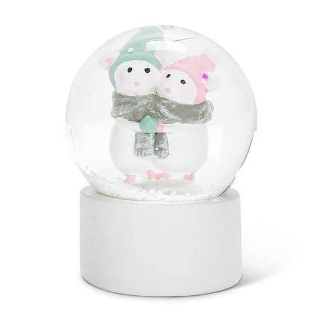 Hugging Winter Mice Mini Snow Globe featuring two resin mice wearing pastel green and pink winter hats and scarves, huddled together inside a clear glass globe. The globe rests on a simple white base and contains white snow-like particles, making it a charming indoor Christmas decoration.