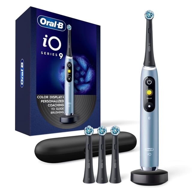 Oral-B iO Series 9 Electric Toothbrush in aqua alabaster with round brush head and interactive color display showing a sun icon and 'HELLO' text, standing on a black charging base, with four black replacement brush heads and a black Power2Go travel case, alongside the product box highlighting personalized coaching and color display features.