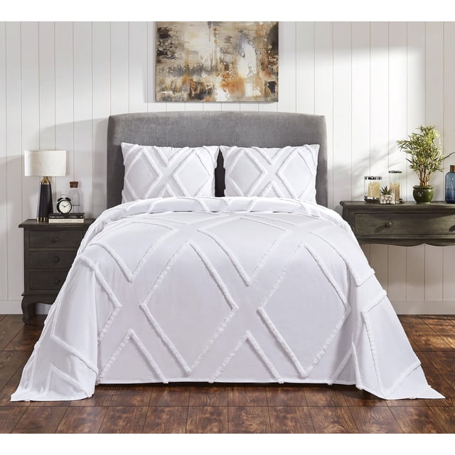 Ensemble de Couvre-Lit en Coton Arizona sur Lit Grand avec Tête de Lit Rembourrée Grise, Comprenant un Couvre-Lit en chenille de Coton Blanc Capitonné et Deux Taies standard Assorties avec un Motif Géométrique en Losanges. la Chambre Présente des Tables de Nuit en Bois Foncé avec une Lampe, une Horloge et des Plantes, Posées contre des Murs à Panneaux Blancs et un Plancher de Bois, Convenant pour Ajouter une Élégance Sombre à la Déco de la Chambre.