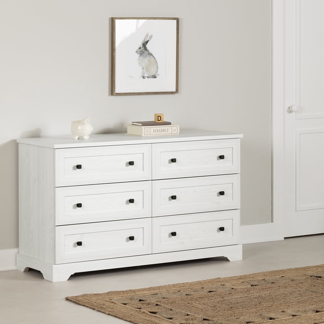 South Shore Hazen 6-Drawer Dresser for Child in white pine finish with farmhouse style, featuring six framed drawers with black square handles and smooth metal slides, positioned against a beige wall with a framed rabbit artwork above and a natural jute rug on the floor, suitable for organizing children's clothing and toys.