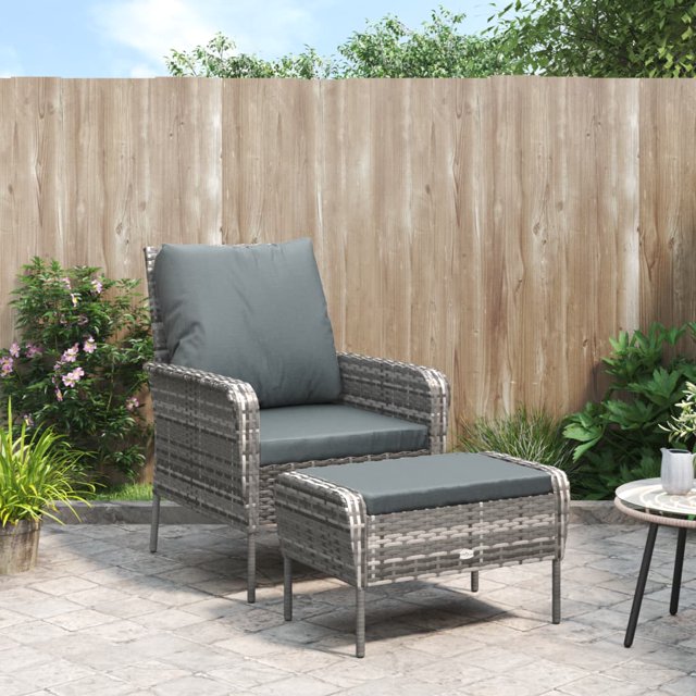 vidaXL Chaise de Jardin avec Repose-Pieds en Rotin poly Gris, Dotée d'Un Cadre en Acier durable et d'Un Matériau en Rotin PE Résistant aux Intempéries. la Chaise Comprend un Dossier Haut, des Accoudoirs et des Coussins anthracite Épais pour un Confort Accru. le Repose-Pieds Assorti Complète la Chaise, Offrant une Expérience d'Assise Relaxante. l'Ensemble Est Exposé sur un patio avec une Clôture en Bois et de la Verdure en Arrière-Plan.