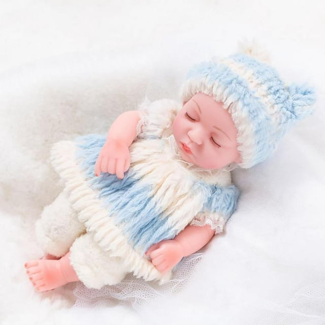 CHOK Toys 11-inch soft reborn baby doll for toddlers, featuring lifelike sleeping details with hand-painted features, vinyl head and limbs, and a soft cotton body. The doll is dressed in a cozy blue and white outfit with matching hat, lying on a white textured surface. Suitable for children aged 3 years and up, ideal for imaginative play, role play, and as an educational toy or birthday gift.