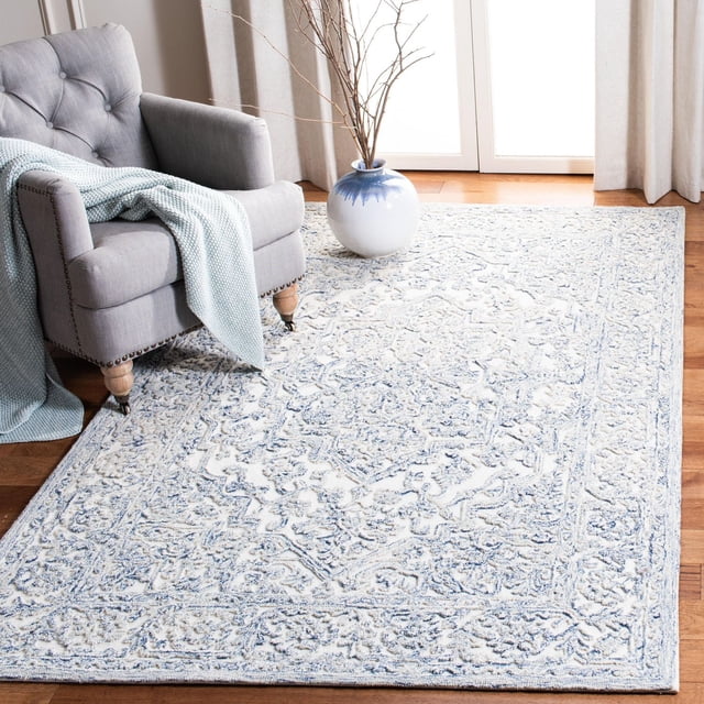SAFAVIEH Trace Donna Tapis Floral Mettant en Vedette des Motifs Floraux Surélevés Complexes en Bleu et Crème sur Laine Tuftée à la Main, Posé sur Plancher de Bois Franc sous un Fauteuil Gris avec un Jeté Tricoté Bleu Pâle et à Côté d'Un vase en Céramique Blanc et Bleu avec des branches Nues, Idéal pour Ajouter Chaleur et texture aux Salons.