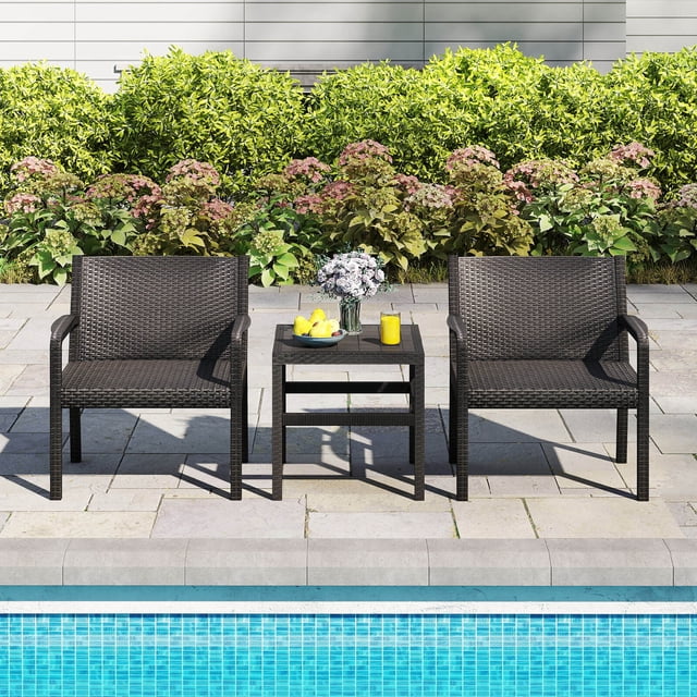 Costway 3 Piece Patio Furniture Set with 2 Modern Rattan Armchairs and a 25-inch square side table in black. The set features a durable PP rattan texture that is waterproof, wear-resistant, and fade-resistant. The ergonomic chairs have wide seats, curved backrests, and armrests, each supporting up to 330 lbs. The 20-inch wide tabletop provides ample space for drinks, snacks, or decorations. Displayed in an outdoor setting by a pool, surrounded by greenery and flowers.