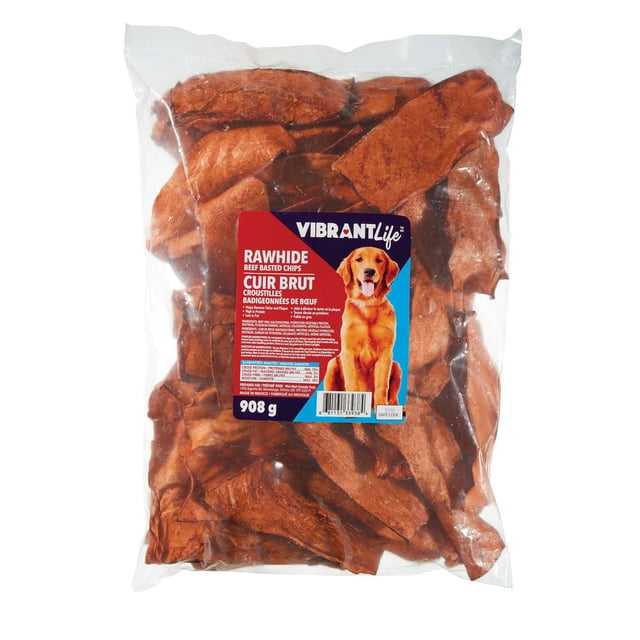 Vibrant Life Beef Basted Chips in a clear plastic bag showing multiple brown rawhide dog treats with a label featuring a dog image and product details highlighting high protein, low fat, tartar removal, and long-lasting chew benefits.