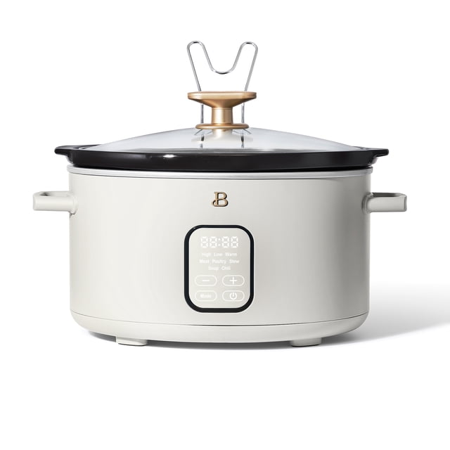 Beautiful by Drew Barrymore Programmable 6-Quart Slow Cooker in off-white with a digital flat screen control panel featuring five preset functions for meat, poultry, stew, soup, and chili, cool-touch handles, removable ceramic pot, tempered glass lid with gold knob and stainless steel lid rest, suitable for cooking meals for up to 7 people and often used for preparing large batch soups or stews.
