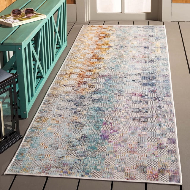 SAFAVIEH Tapis d'Aire Intérieur/extérieur à Motif Abstrait de Jammel Arc-en-Ciel sur Plancher de Terrasse en Bois, Présentant un Tissage Rectangulaire en Polypropylène avec un Motif Abstrait Pixélisé dans des Tons Bleu, orange, Ivoire et Violet. Ce Tapis d'Aire Extérieur durable, Résistant à la Décoloration et à l'Eau Est Placé à Côté d'Un Banc Sarcelle avec des Lunettes de Soleil et un Livre, Convient aux patios, Balcons Ou Salons.