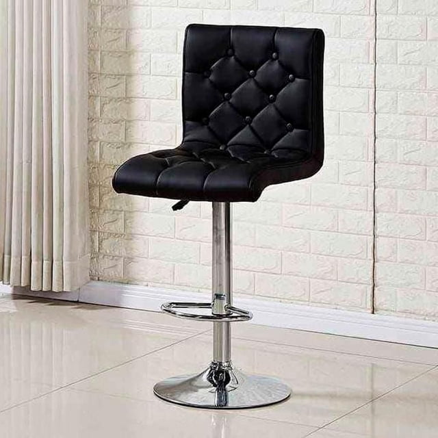 Heavenly Collection Black Leather Adjustable Stool with button tufted black PU leather seat and backrest, ergonomic curved design, adjustable height gas lift, 360° swivel, and polished stainless steel base with footrest, shown in a tiled room with white brick wall and beige curtains. It is also suitable for use as a stylish seating option in home bars or kitchen islands.