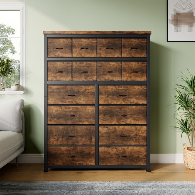 Yiwa Commode Haute à 16 Tiroirs, une Commode en Tissu avec un Cadre Métallique Robuste et un Dessus en Bois, Conçue pour la Chambre, le Garde-Robe Ou le Couloir. la Commode Présente une Finition Brun Rustique avec des accents Noirs et 16 Tiroirs en Tissu pour Organiser des Vêtements, des Accessoires Ou des Articles Ménagers. Comprend des Pieds en Plastique Ajustables pour la protection du Plancher et une Capacité de Montage Mural pour une Stabilité Accrue. Exposée dans une Pièce Moderne avec un Mur Vert, un sofa Blanc et une Plante en Panier Tressé à Proximité.