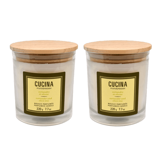 Fruits & Passion Cucina Perfumed Plant Based Wax Candle 7.7 Ounces - 2 Pack. Two glass jar candles with wooden lids, featuring a coriander and olive tree fragrance. Each jar has a yellow label with the Cucina branding. Handmade with plant-based wax, these candles are eco-friendly, recyclable, and offer an approximate burn time of 35 hours. Suitable for home décor and creating a Mediterranean-inspired aromatic ambiance.