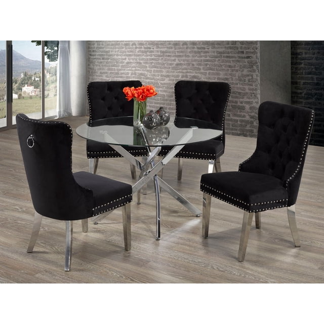 Margot Ensemble de Salle à Manger 5 Pcs, Noir avec un Plateau Rond en Verre Trempé de 44 Pouces sur une base Astérisque Chromée, Accompagné de Quatre Chaises Rembourrées Capitonnées Noires avec Garniture de Clous Argentés, Pattes Chromées et Poignées Anneau en Métal au Dos, Disposé sur un Plancher de Bois Clair contre un Mur de Briques Gris Près d'Une Grande Fenêtre, Idéal pour les Salles à Manger Contemporaines.