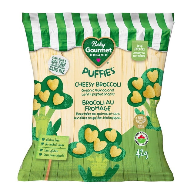 Baby Gourmet Organic Puffies Cheesy Broccoli snack bag with green and white striped top and wood-textured background, showing heart-shaped yellow puffed snacks on illustrated broccoli trees, labeled gluten free, no added sugar, corn, grain and rice free, certified organic, purity award, 42g, ideal for introducing new flavors and developing baby's pincer grasp.