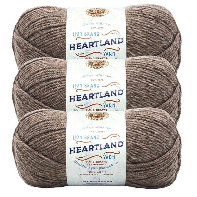 Lion Brand Yarn Heartland Yarn 3Pack showing three skeins of medium worsted weight acrylic yarn in a heathered brown colour, each with a white label featuring the brand and product name. This machine washable, durable yarn is suitable for knitting, crochet, and often used for crafting home décor items.