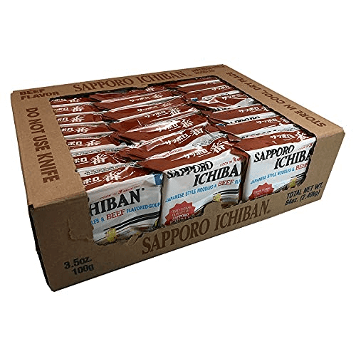 SAPPORO Ichiban Japanese Style Noodles, Beef flavor, 100 g packets in a bulk case of 24. The image shows the cardboard packaging containing individually wrapped noodle packs with red and white branding, neatly arranged in rows. Ideal for quick and flavorful meals, these noodles feature a rich beef soup base and are perfect for stocking up.