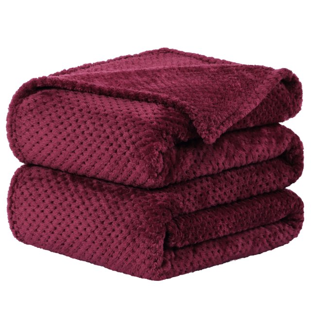 Unique Bargains Luxury Fleece Bed Blanket Woven Mesh in burgundy color, made of 100% polyester with a 300GSM weight. Features a soft, breathable texture with a woven mesh design for warmth and air permeability. Suitable as a bed blanket or throw blanket for bedding and home décor. The blanket is folded neatly, showcasing its plush and smooth surface.