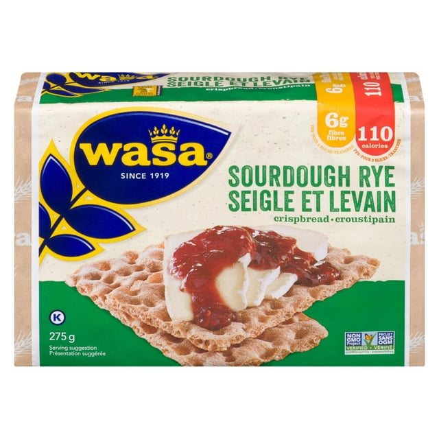 Wasa Sourdough Rye Whole Grain Crispbread 275gr package showing two rectangular rye crispbreads topped with cheese and red jam, featuring the Wasa logo, 6 grams of fibre, 110 calories, kosher symbol, and non-GMO verified labels on a beige and green background. This crunchy sourdough rye crispbread is suitable for pairing with various snack toppings.