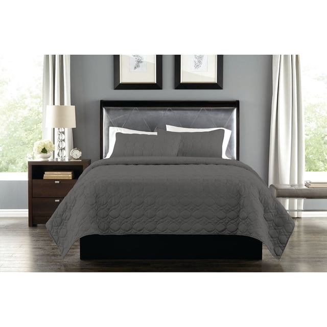 Springmaid Ensemble de Courtepointe 3 Pcs Couleur Charbon sur un Lit avec une Tête de Lit en Cuir Foncé, Comprenant une Courtepointe et Deux Couvre-Oreillers Assortis avec Motifs Matelassés Circulaires, dans une Chambre avec Murs Gris, Rideaux Blancs, Table de Nuit en Bois avec Lampe et Horloge, et Plancher de Bois Franc, Idéal pour Créer une Atmosphère de Chambre Sereine et Élégante.