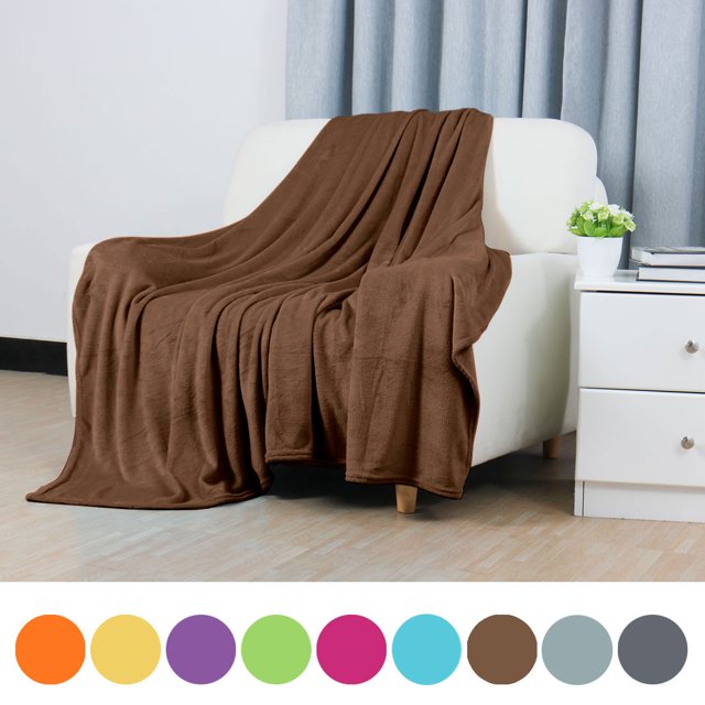 PiccoCasa 1 Pcs Home Warm Soft Microplush Fleece Solid Throw Blanket in chocolate color, measuring 70 x 78 inches, draped over a white couch in a modern living room setting. Made of 100% polyester microfiber, this lightweight and soft blanket provides insulation suitable for all seasons. Machine washable for easy care, it is ideal for beds, couches, or camping.